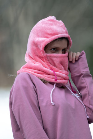 Portrait of a girl in a pink hoodie in the park