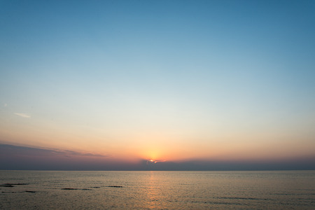 colorful sunset in the sea with reflections and cloudsの写真素材