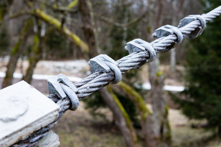 details from metal of wooden suspension footbridge over river in autumnの写真素材