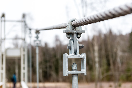 details from metal of wooden suspension footbridge over river in autumnの写真素材