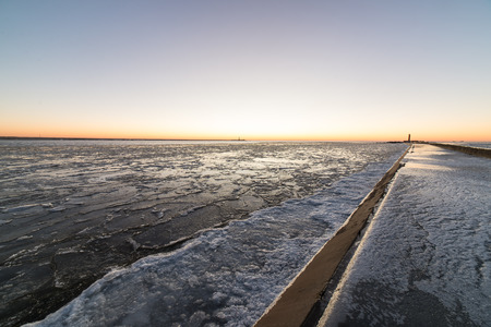 sunset over frozen sea with ice blocks and dramatic colorful sky