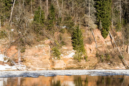 frozen river in winter with sandstone cliffs and ice blocks. Gauja National Park. Latvia.の写真素材
