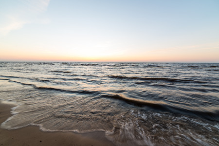 Shoreline of Baltic sea beach with rocks and sand dunes under cloudsの写真素材