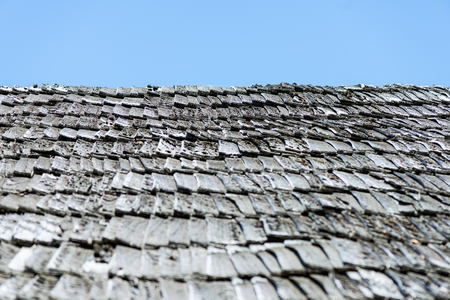 old countryside house with brick chimney and wooden roofの写真素材