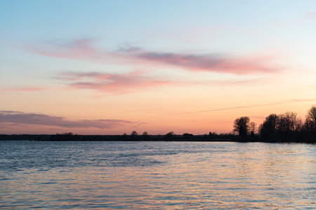 beautiful sunrise over the lake in country with warm colors and reflectionsの写真素材