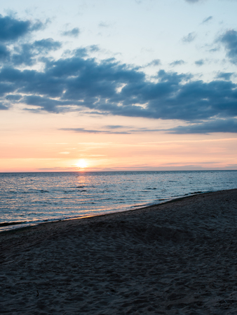 red and orange dramatic sunset on the sea beach with colorful skyの写真素材