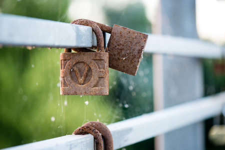 rusty metal locks on the bridge with blur backgroundの写真素材