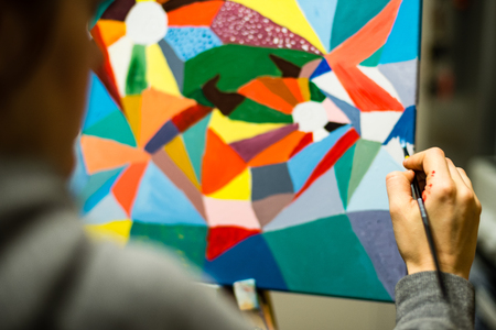 artist painting with acrylic colors and mixing tones on the pallet. blur background abstract photoの写真素材