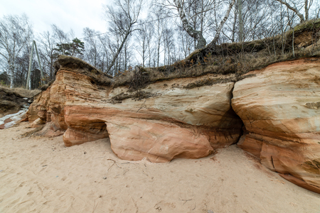 sandstone cliffs by the river in Gauja national park in latviaの写真素材