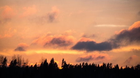 Colorful sunset over the fields in countryside with dramatic cloudsの写真素材