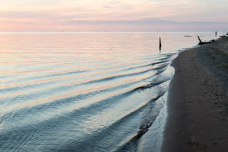 Reflections in the calm lake water with dramatic clouds with small boatの写真素材