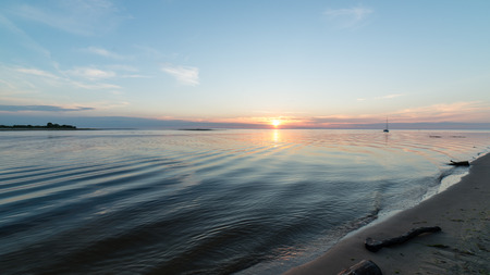 Beautiful sunset over the sea with clouds and reflectionsの写真素材