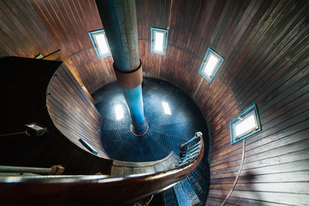 A spiral staircase inside a old wooden lighthouse.