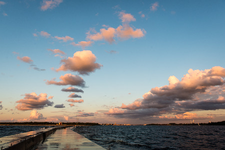 wavebreaker in the sea with waves crushing over in sunsetの写真素材