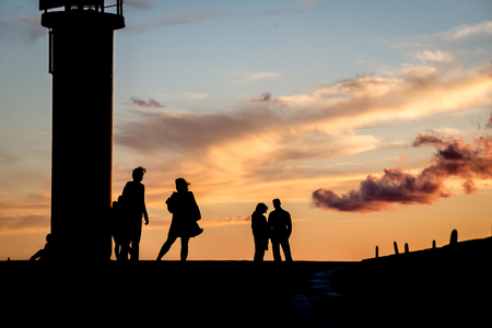 lighthouse with rusty metal rails near sea port  and silhouettes.の写真素材