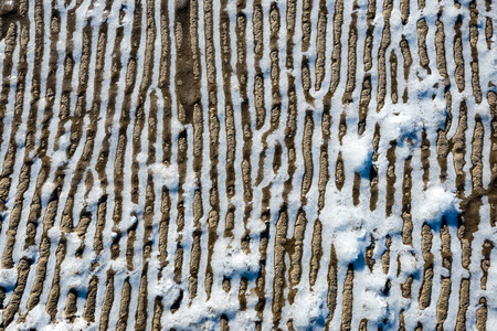frozen sand with ice blocks. abstract texture in natural beachの写真素材