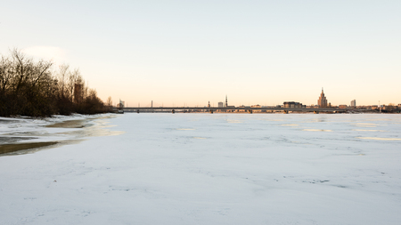 frozen beach in cold winters day with colorful sky and iceの写真素材