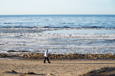 people enjoying frozen beach in winters cold. walking and relaxingの写真素材