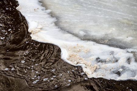 frozen countryside scene in winter with snow. iced river with blocks of iceの写真素材
