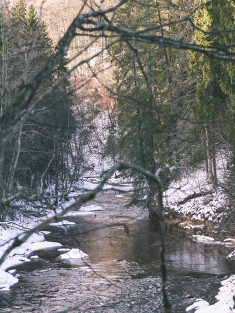 frozen countryside scene in winter with snow. iced river with blocks of iceの写真素材