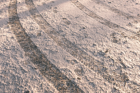 car tire tracks on winter road in deep snow in lonely forest - vintage effectの写真素材