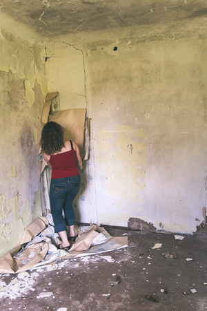 depressed young girl in old house interior trashing walls - vintage effectの写真素材