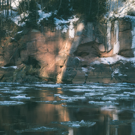 frozen river in winter with sandstone cliffs and ice blocks. Gauja National Park. Latvia. - instant vintage square photoの写真素材