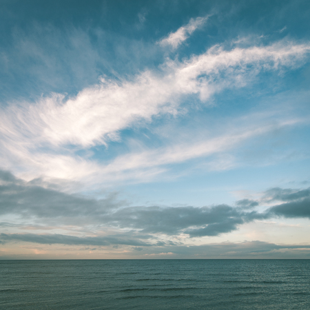baltic beach in fall with clouds and waves towards deserted dunes. cloudy day - instant vintage square photoの写真素材