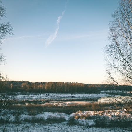 beautiful snowy winter landscape with trees and blue sky - instant vintage square photoの写真素材