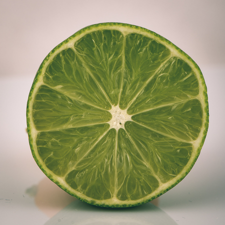 slice of lime isolated on white background - instant vintage square photoの写真素材