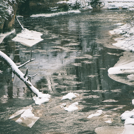 Frozen winter river landscape with ice and snow - instant vintage square photo