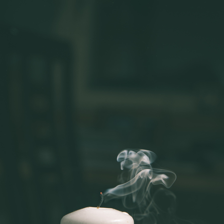 Smoke coming from a blown out candle with dark background - instant vintage square photoの写真素材