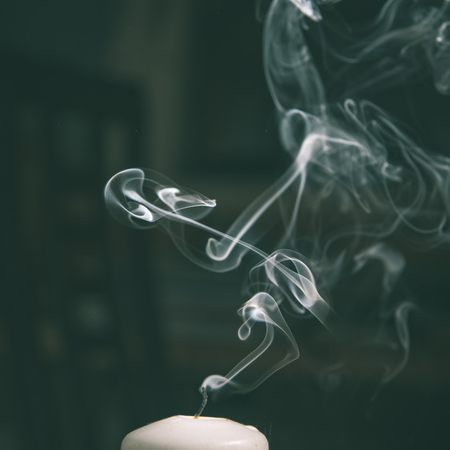 Smoke coming from a blown out candle with dark background - instant vintage square photoの写真素材