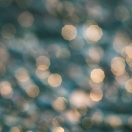 out of focus blur background with sea water in sunset light - instant vintage square photoの写真素材