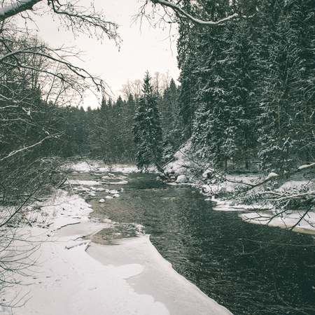 Frozen winter river landscape with ice and snow - instant vintage square photo