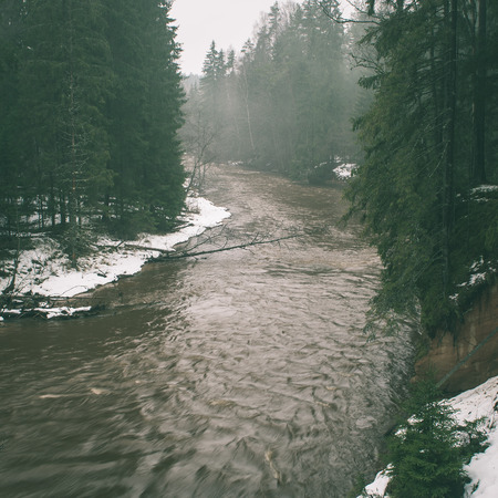 scenic winter colored river in country with snow and trees - instant vintage square photoの写真素材