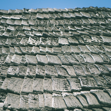 old countryside house with brick chimney and wooden roof - instant vintage square photoの写真素材
