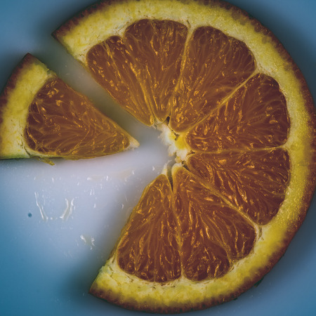 slice of orange isolated on white background. fruit pie chart - instant vintage square photoの写真素材