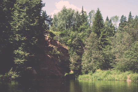 Picturesque river view with clouds and trees in the background - retro, vintage style lookの写真素材