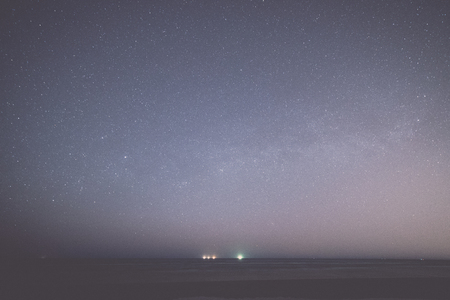 night sky with stars on the summer beach. space view from earth - retro, vintage style lookの写真素材