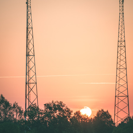 red sun in sunrise between two towers - instant vintage square photo
