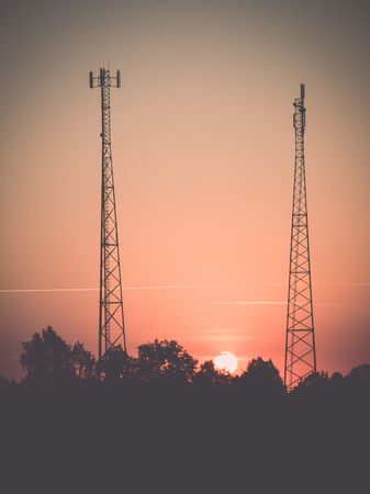 red sun in sunrise between two towers - retro, vintage style look