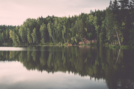river with reflections in weater and sandstone cliffs in latvia - retro, vintage style lookの写真素材