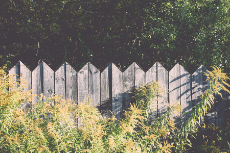 old wooden fence with barbed wire on top - retro, vintage style lookの写真素材