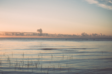 beautiful sunrise in the sea at the wild beach - retro, vintage style lookの写真素材