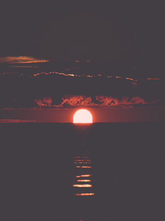 beautiful sunrise in the sea at the wild beach. Vintage photography effect.の写真素材