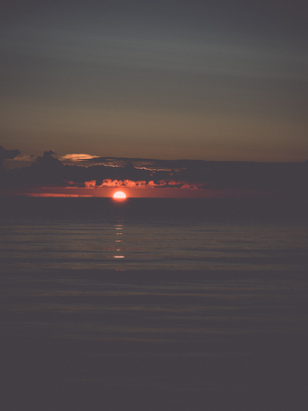 beautiful sunrise in the sea at the wild beach - retro, vintage style lookの写真素材