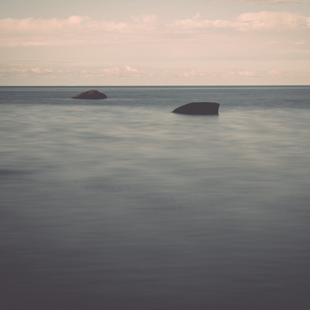 rocky beach in the baltic sea with plants and skyline - retro, vintage style lookの写真素材