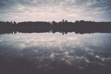 reflection of clouds in the lake with boardwalk and trees in background - retro, vintage style lookの写真素材