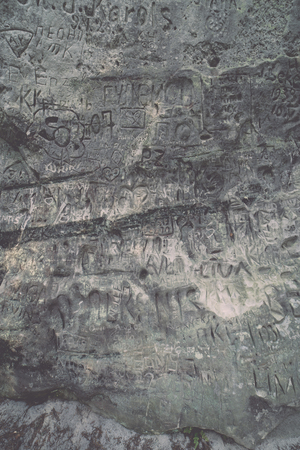 ancient sandstone cliffs with inscriptions in the Gaujas National Park, Latvia - vintage retro lookの写真素材